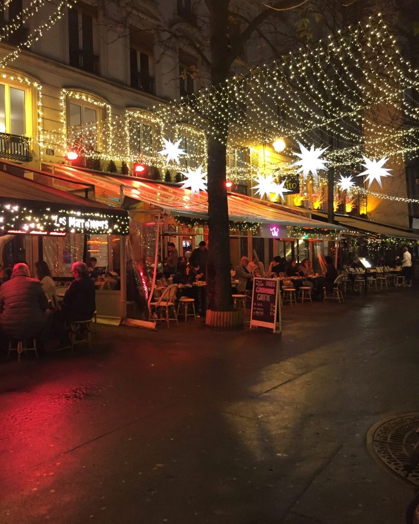 lights illuminated an outdoor terrasse in Paris