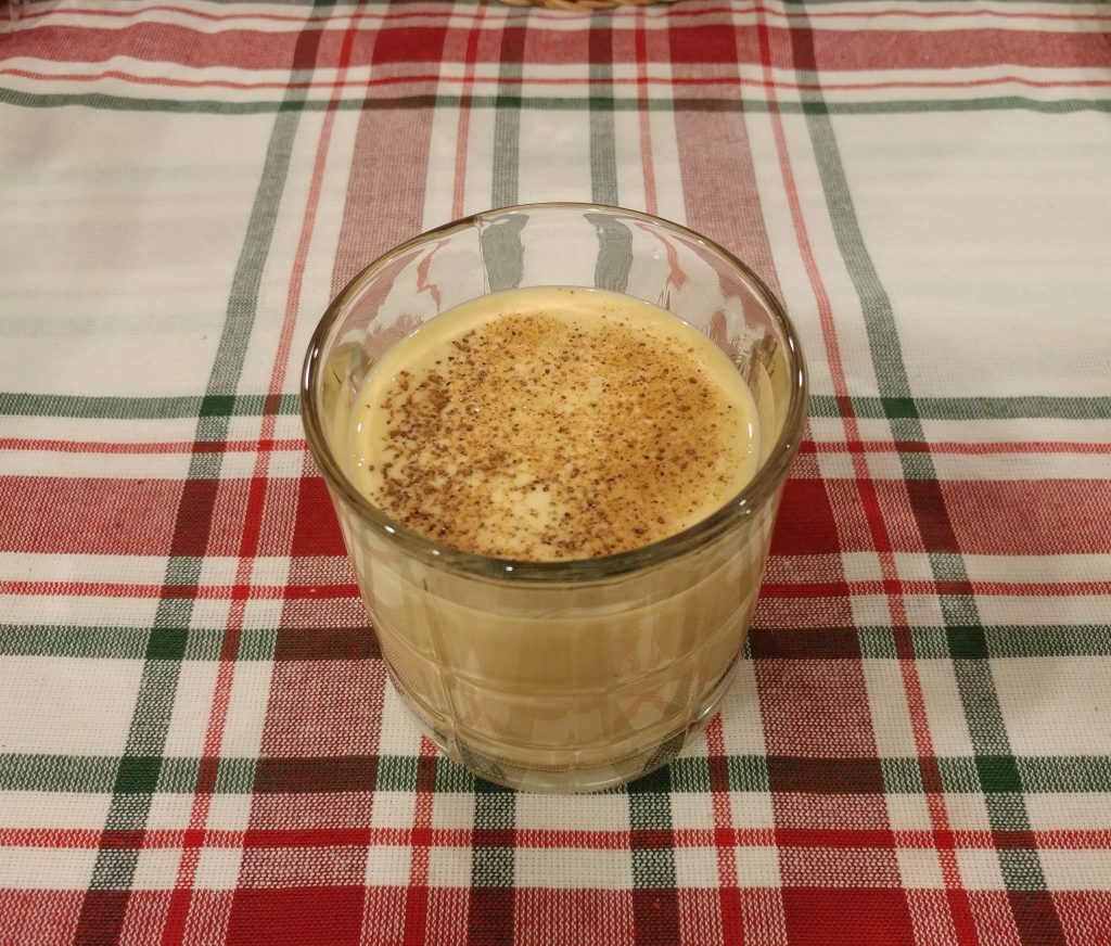 glass of eggnog with nutmeg sprinkled on top