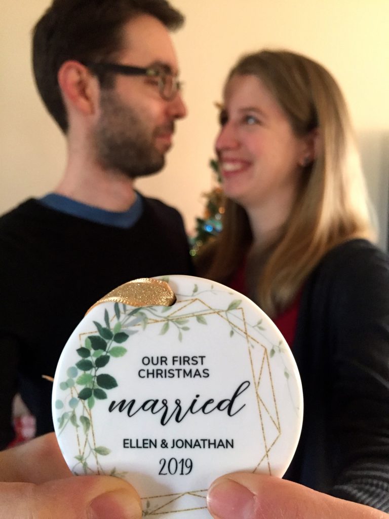 first married Christmas ornament held by newlyweds