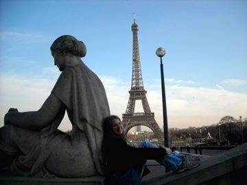 sitting against a statue with Eiffel Tower in background
