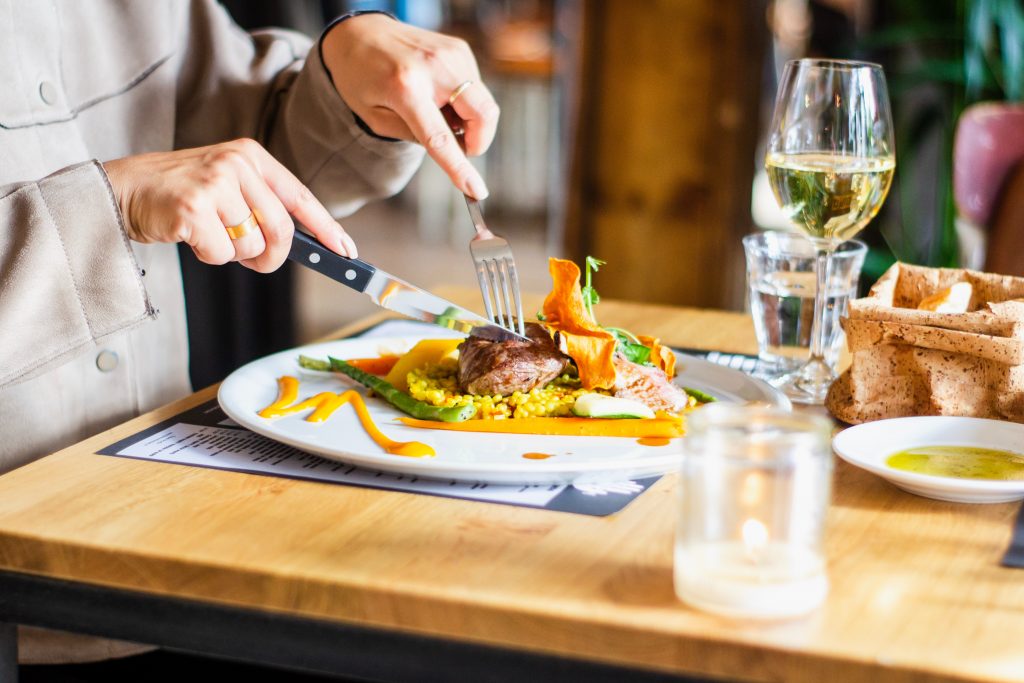 eating with fork in left hand, knife in right hand