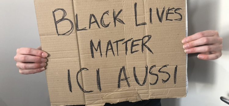 Sign on cardboard: Black Lives Matter Ici Aussi