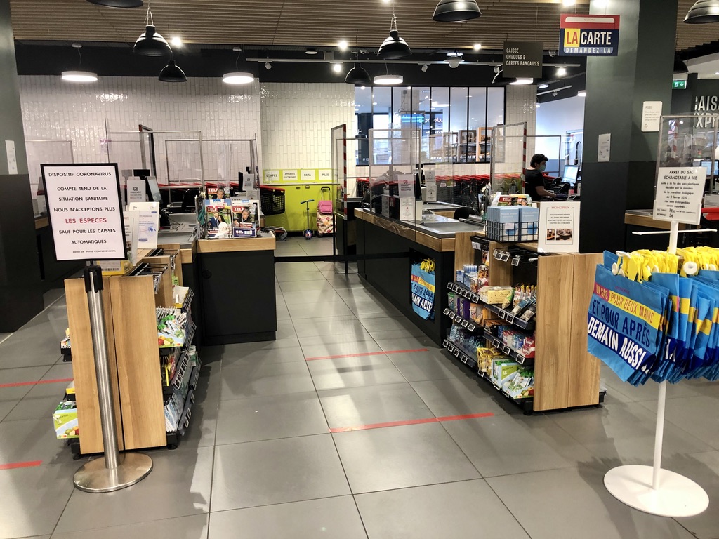 permanent clear barriers installed in front of cashiers at the grocery store
