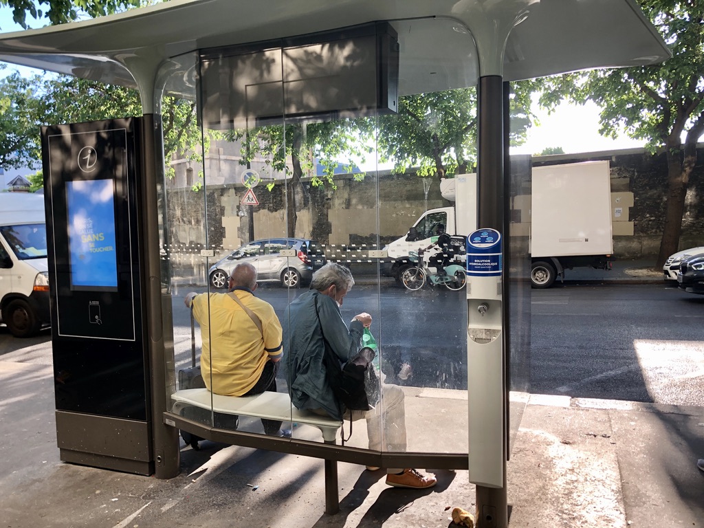 hand sanitizer container placed at a bus stop in Paris