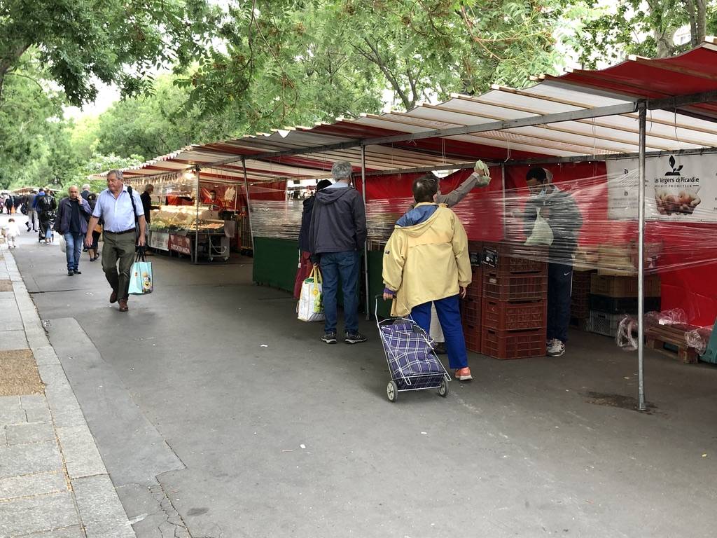 plastic barrier wrapped around stands at the open air market in Paris