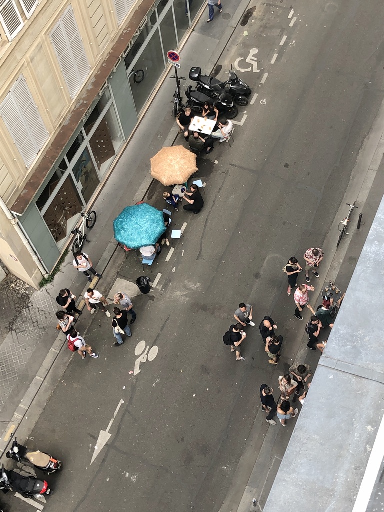 people gathering outside of a bar in the street during Covid