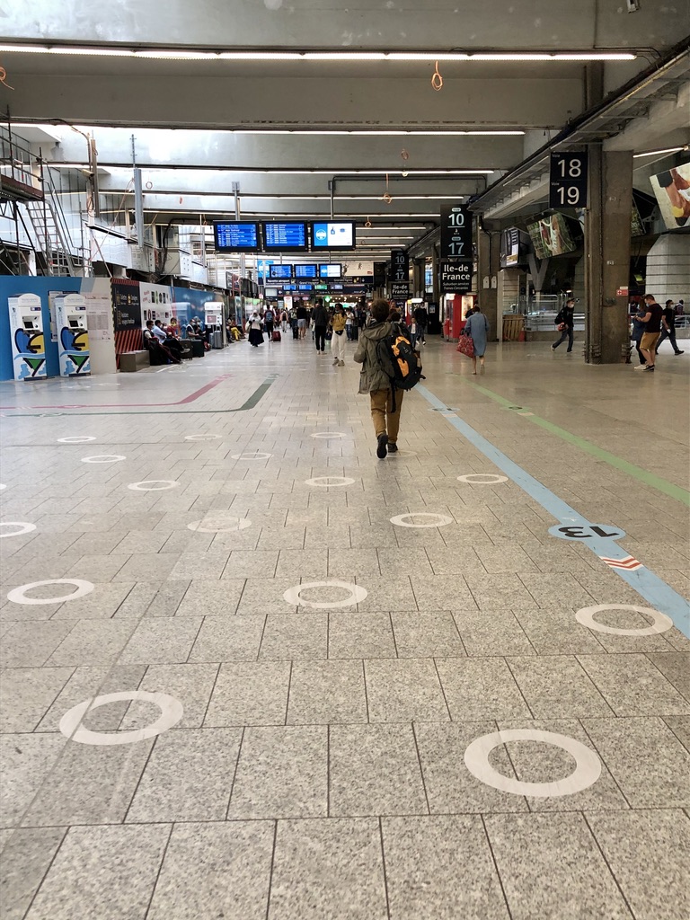 white circles on the ground to encourage spacing between people at the train station