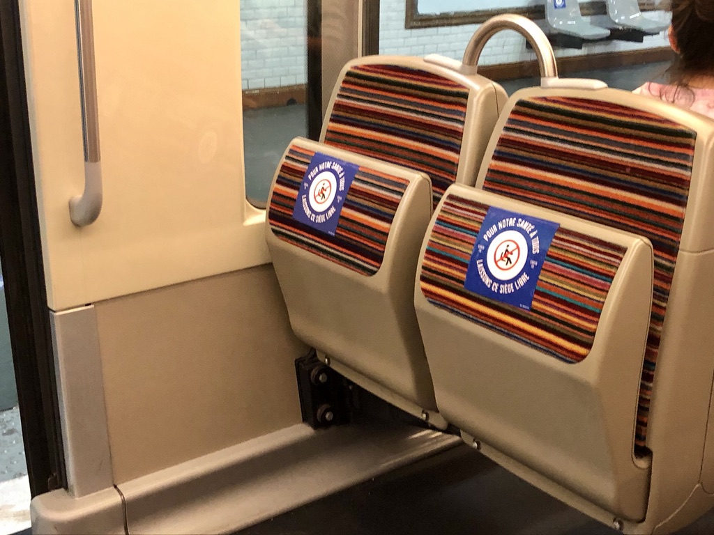 stickers telling people not to sit on the metro in Paris