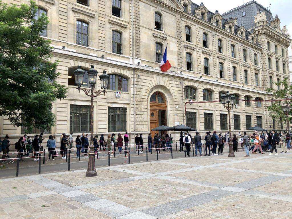 Paris prefecture with long line of people waiting outside