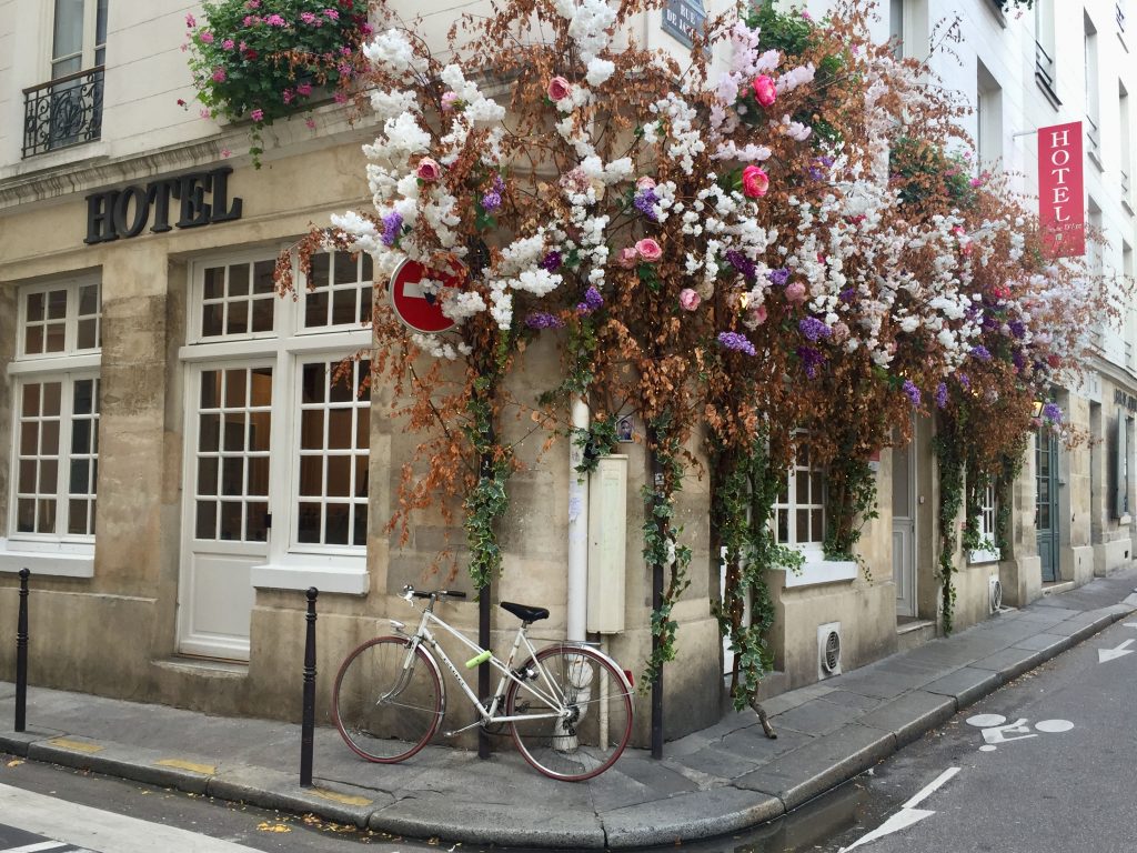 Hotel Jeanne d'Arc in the Marais decorated with flowers and a bike outside