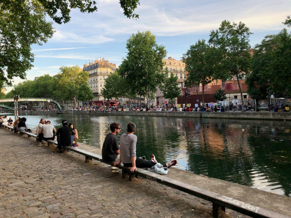Canal Saint Martin in the summer with groups of people sitting around