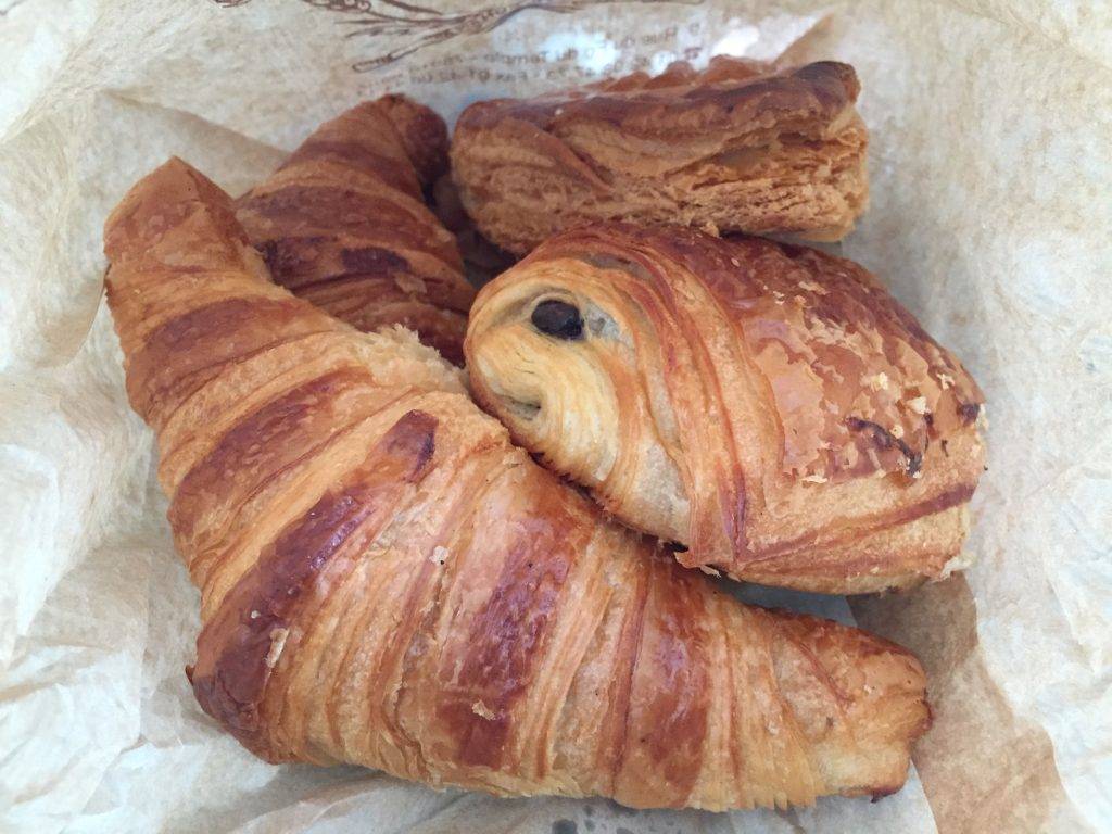 croissants and pains au chocolat in a paper bag