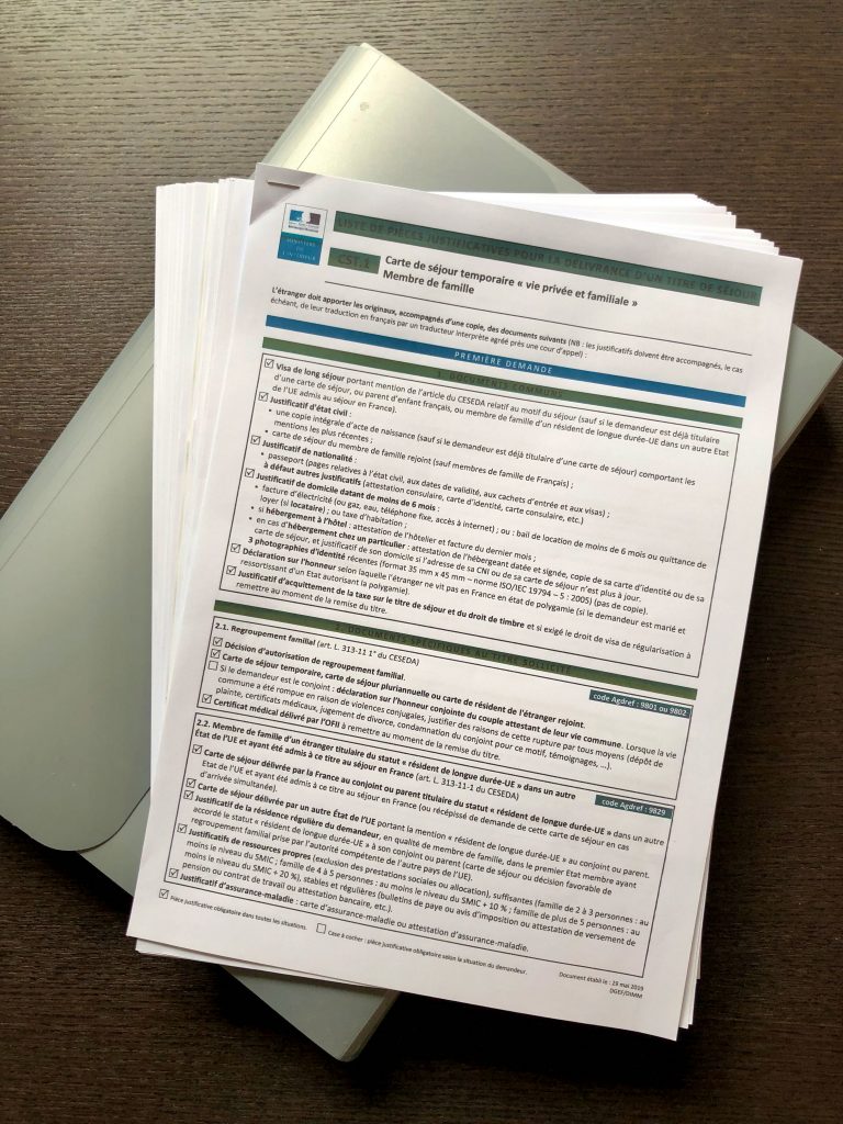stack of documents required and prepared for renewing a French carte de séjour (residence permit)