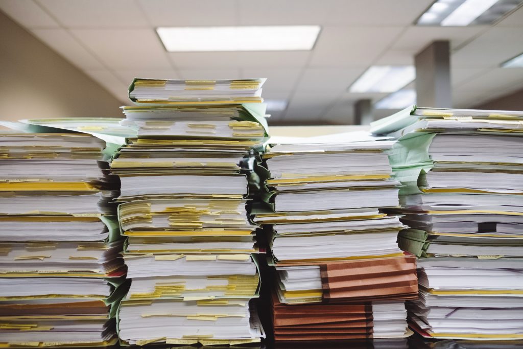 stacks of papers in folders lined up in a row