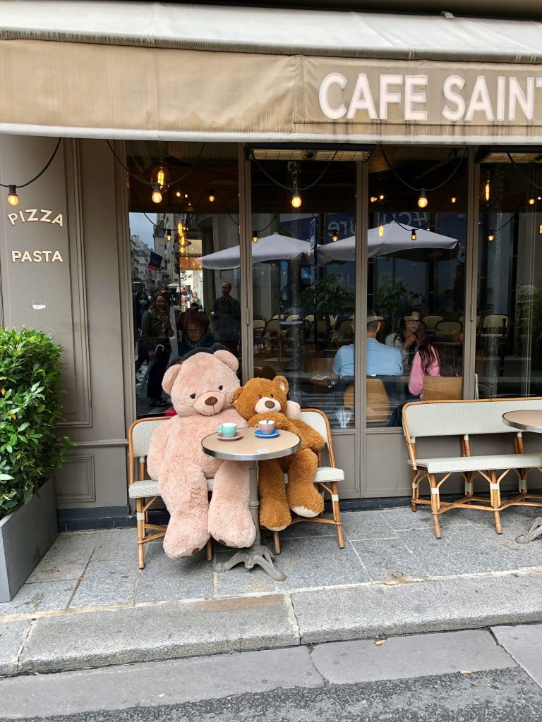 two huge teddy bears sitting outside a Paris café having a coffee
