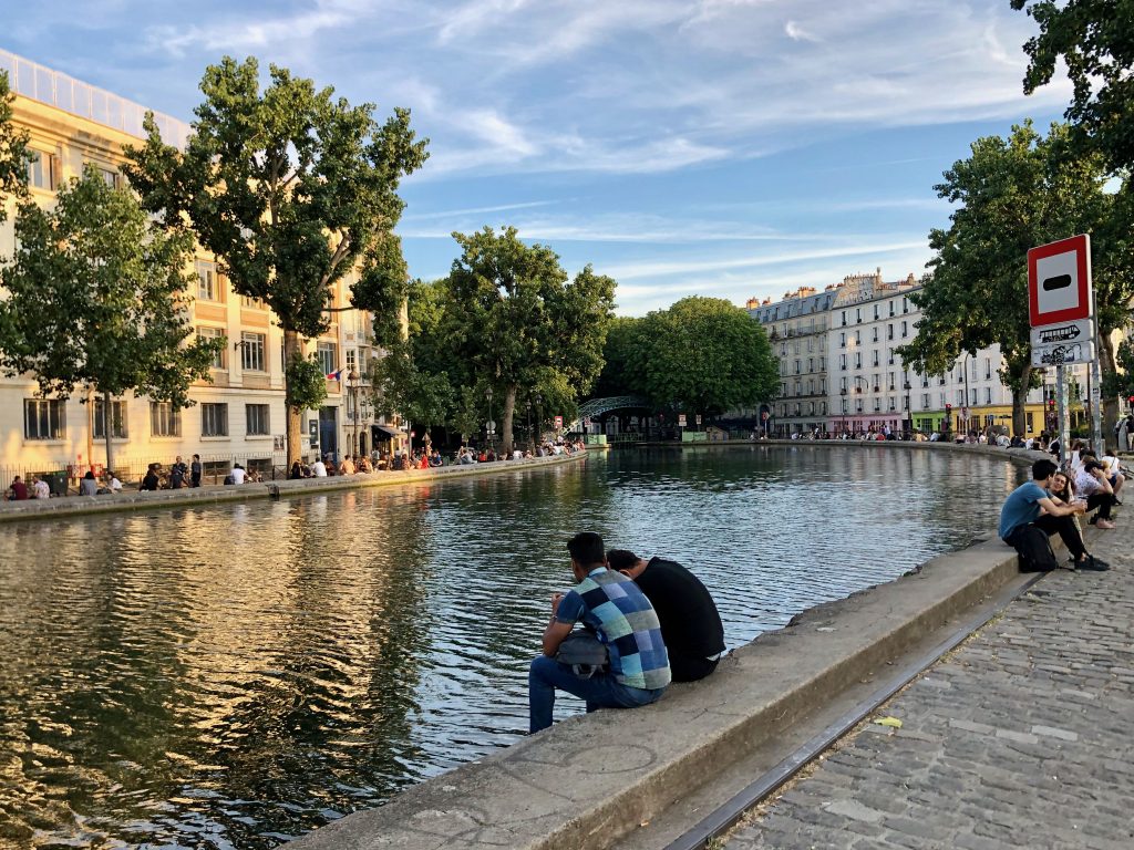 People sitting along Canal Saint-Martin at golden hour