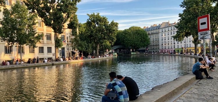 People sitting along Canal Saint-Martin at golden hour