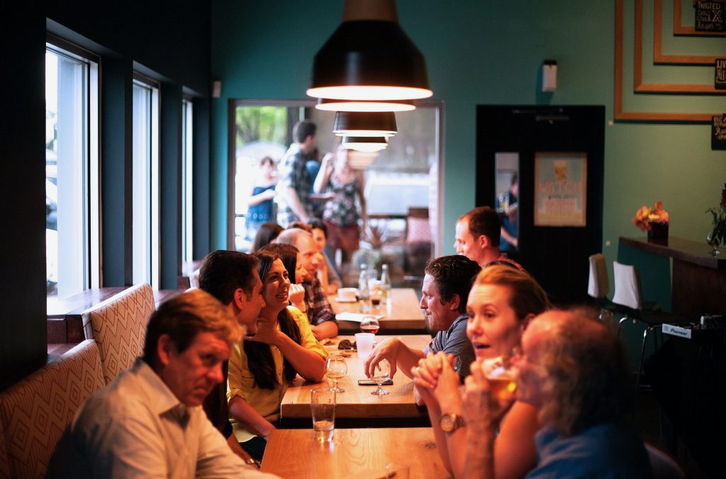 large group of people sitting indoors, talking