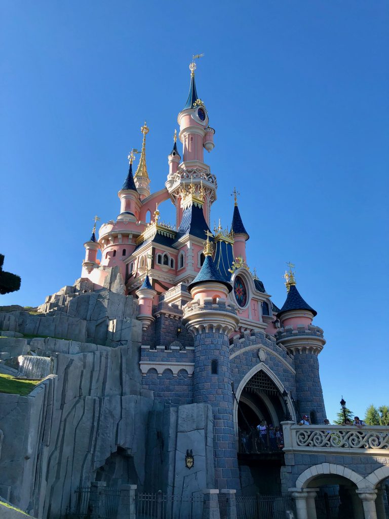 pink Sleeping Beauty Castle with a clear blue sky in the background at Disneyland® Paris