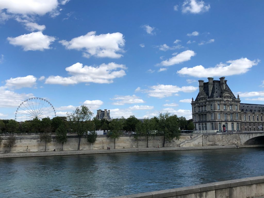 ferris wheel visible across the river in the summer fête foraine in the Jardin des Tuileries
