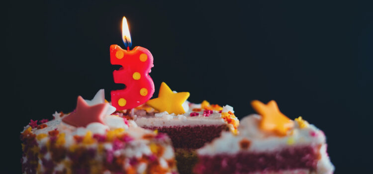 number 3 candle lit on top of a birthday cake