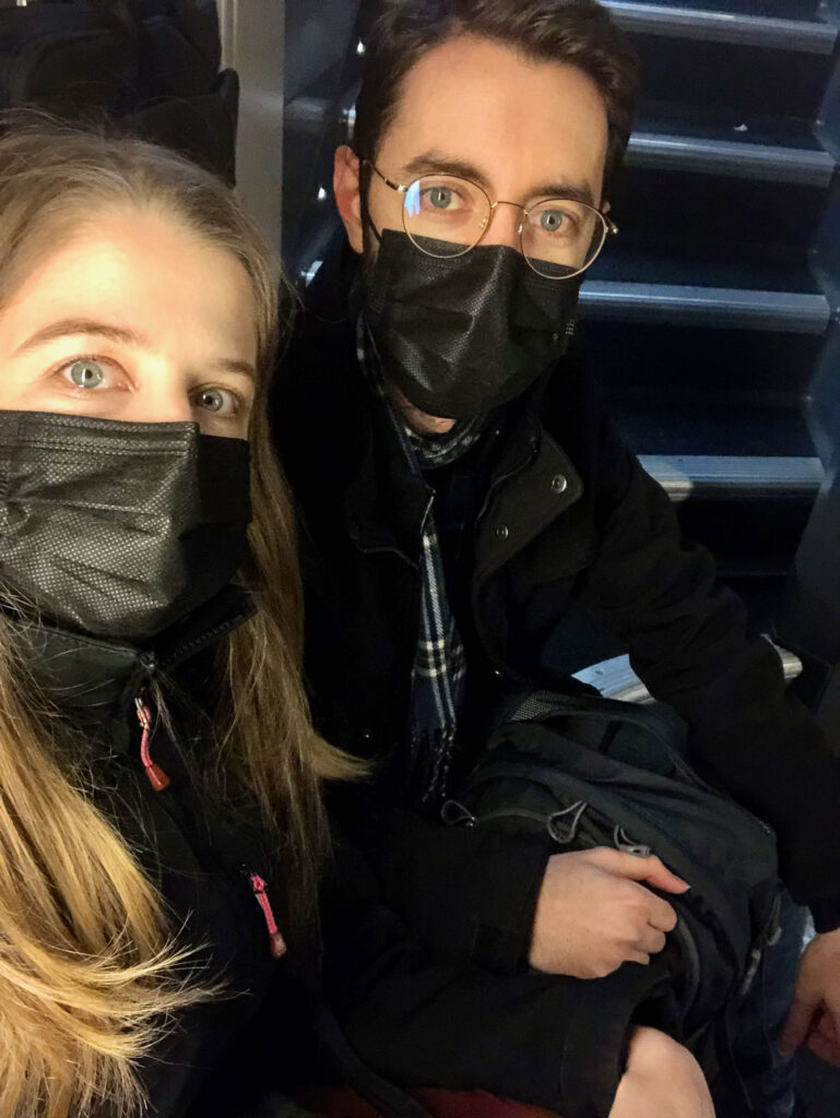 woman and man sitting on the stairs of a train leaving Paris