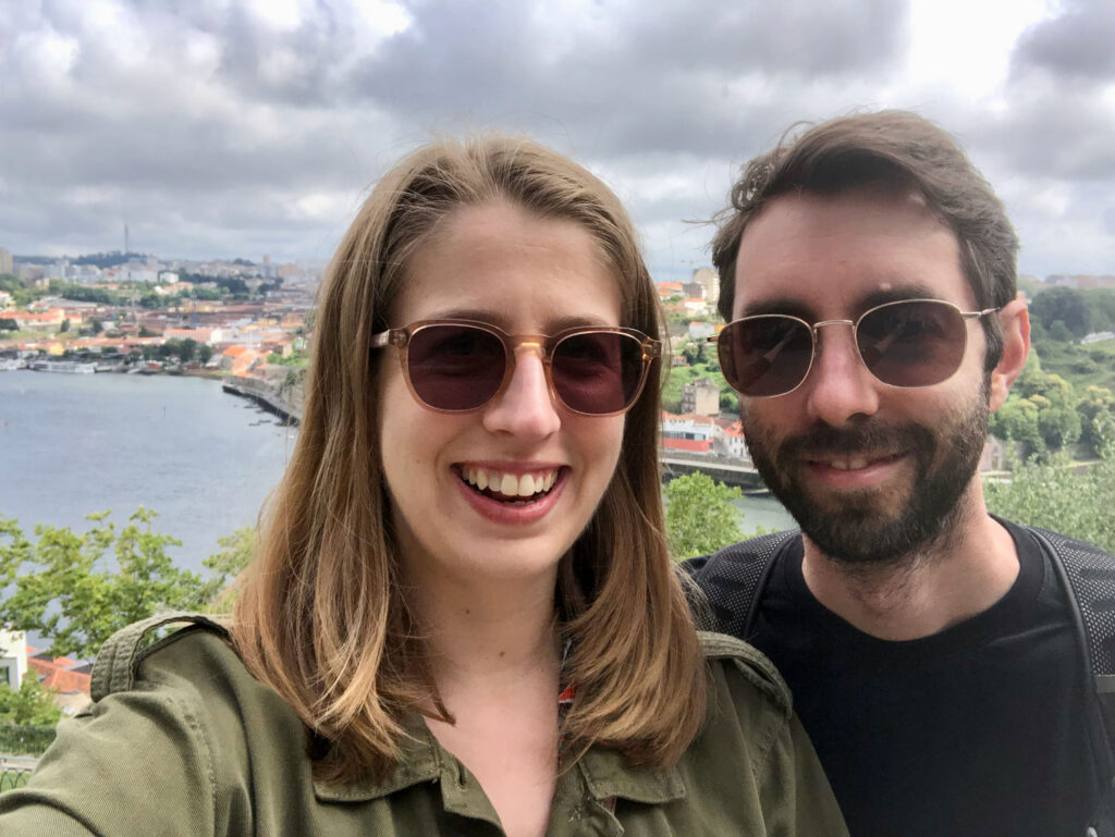 selfie of woman and man standing side by side in Porto with Douro River in background