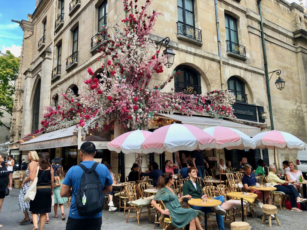 outdoor Paris café terrace, decorated with flowers in various shades of pink
