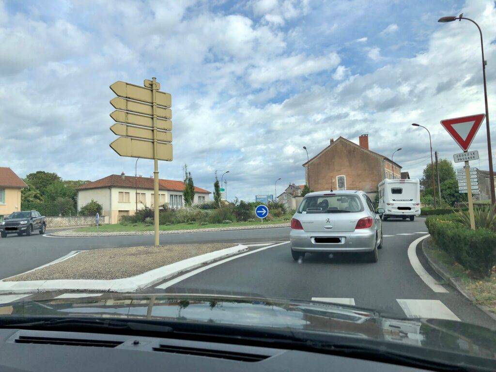 red and white triangular sign with the words cédez le passage to indicate that drivers entering the roundabout have to yield