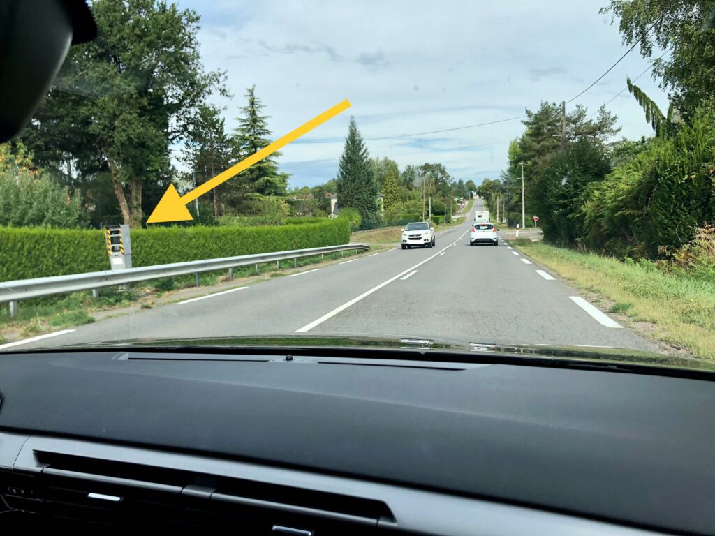 yellow arrow pointing to a radar used to check speeds of passing cars on French roads