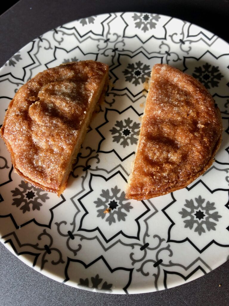 kouign-amann, a buttery, Breton pastry, cut in two on a plate