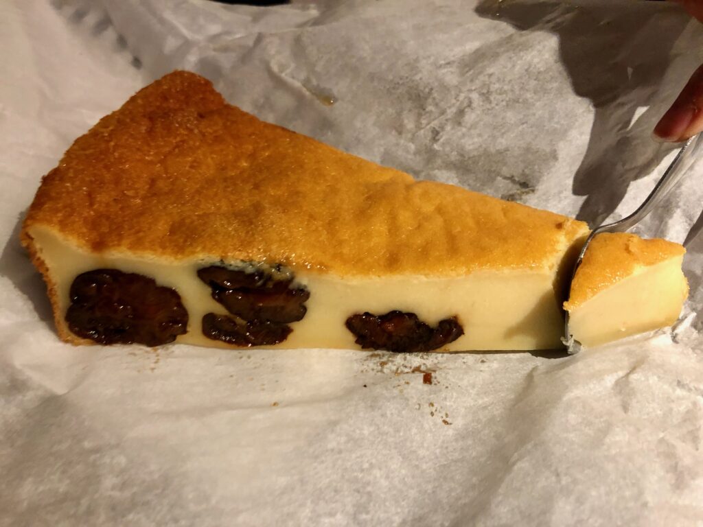 a slice of far breton cake with prunes on white paper