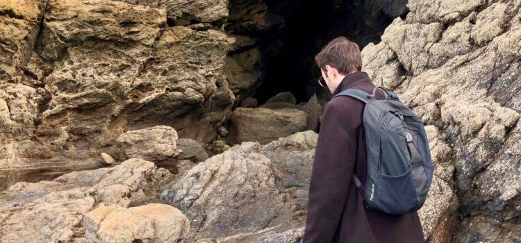 man with Osprey daylite backpack walking towards the Grotte des fées in Dinard, France