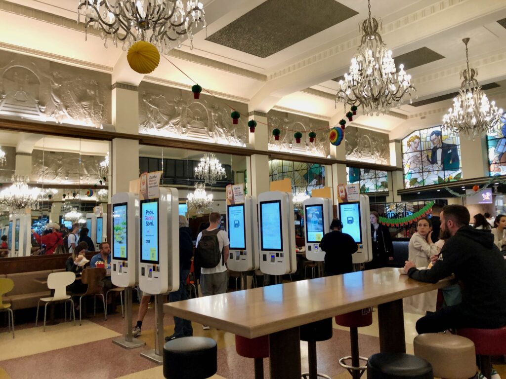 chandeliers hanging from the ceiling and electronic kiosks in the McDonald's of Porto, Portugal