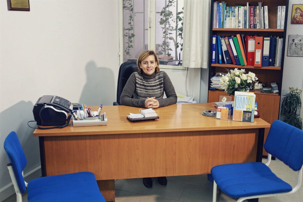 woman sitting behind a desk in a casual office space, much like what you'd expect seeing when going to the gynecologist in France