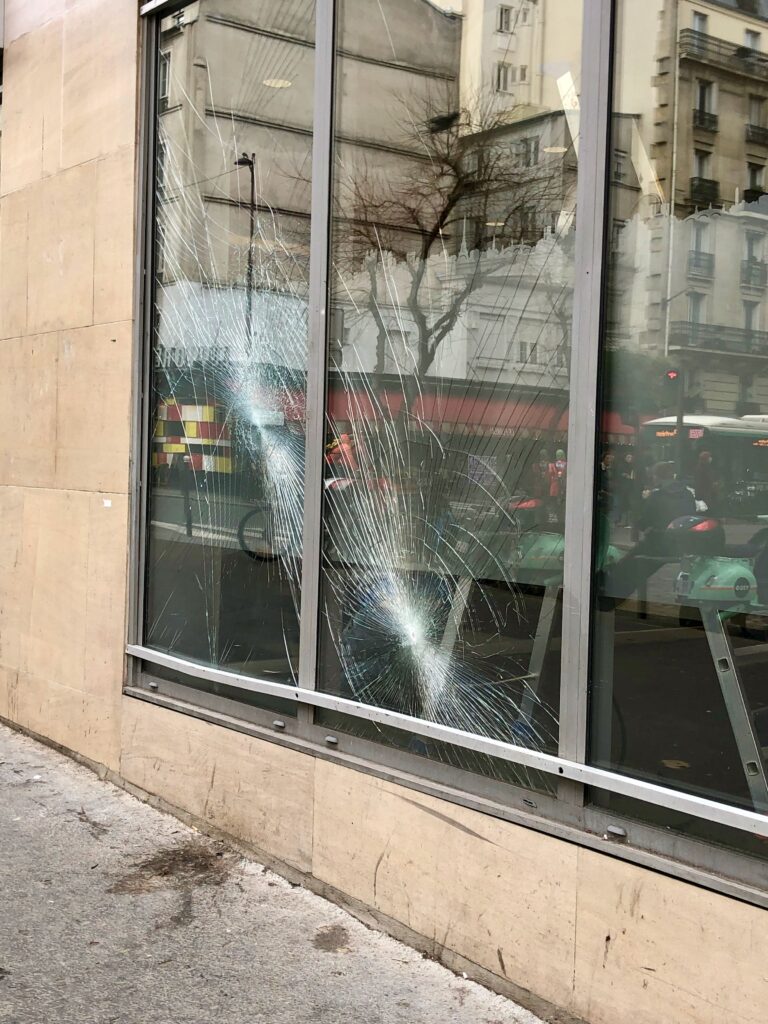cracked bank window, broken by protesters in Paris during protest against retirement reforms in 2023