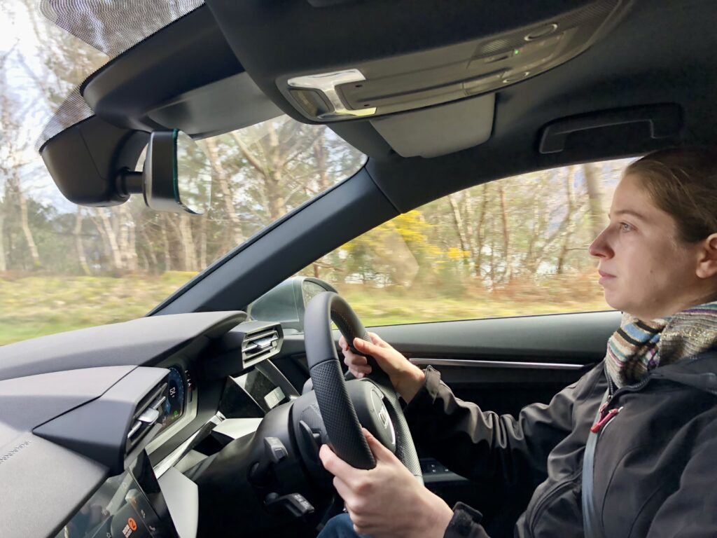 side profile of an American woman driving on the right side of the car and on the left side of the road in the UK (Scotland)