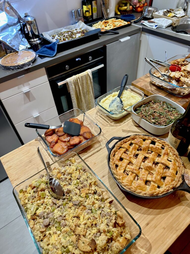 Casserole dishes lined up on the counters and loaded with common Thanksgiving side dishes for a dinner hosted by an American family in France