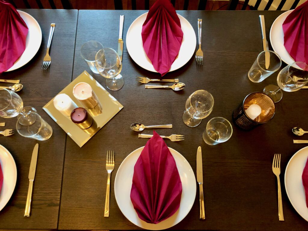 Napkins, plates, and cutlery set out in preparation of Thanksgiving dinner hosted in France by an American family.
