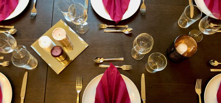 Napkins, plates, and cutlery set out in preparation of Thanksgiving dinner hosted in France by an American family.