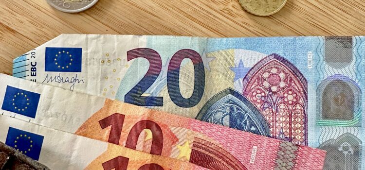 Do You Need Cash in Paris? Euro coins and bills spilling out of a brown wallet