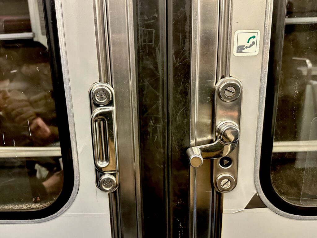 To open the door on an older Paris metro train, lift the lever / handle