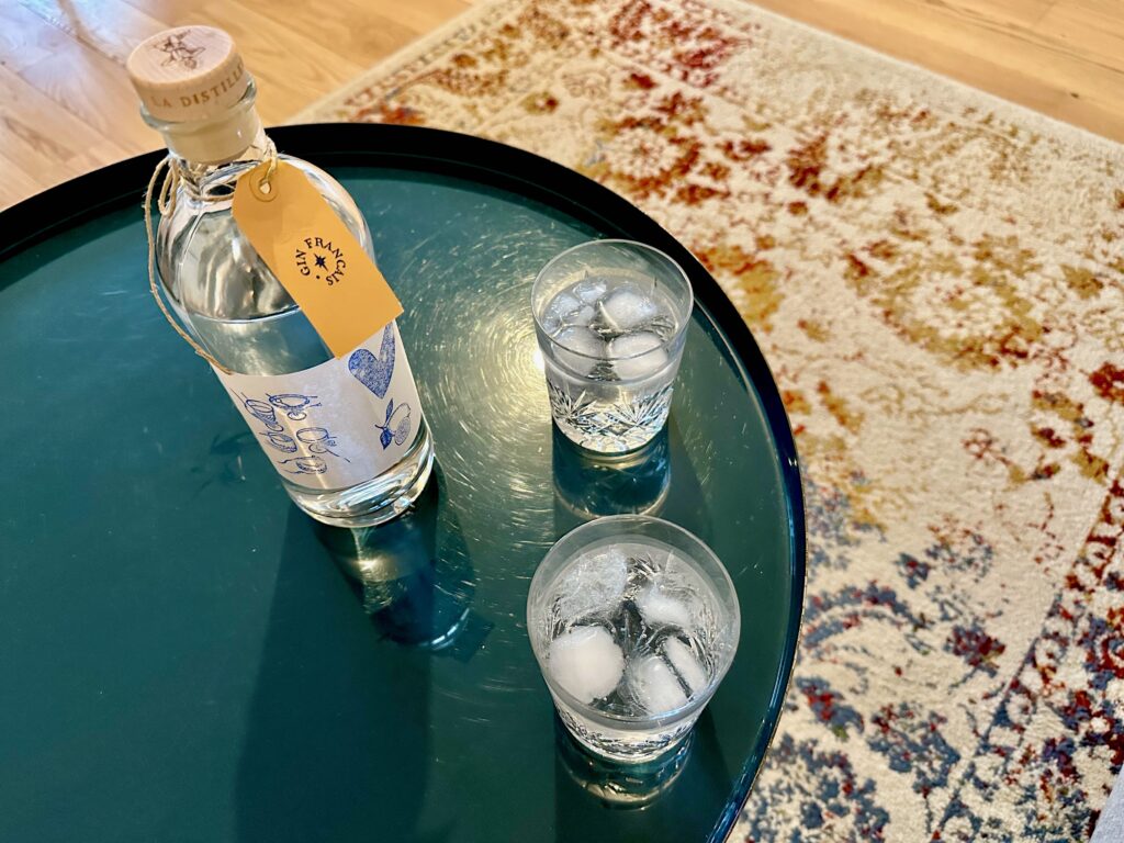 custom bottle of French gin and two glasses of gin and tonic