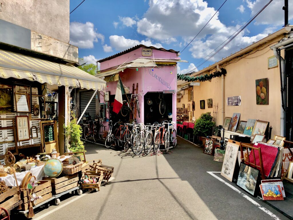Bicycle shop, art vendor, and antiques on display in the marché vernaison, one of the open-air markets at the Paris Saint-Ouen flea market