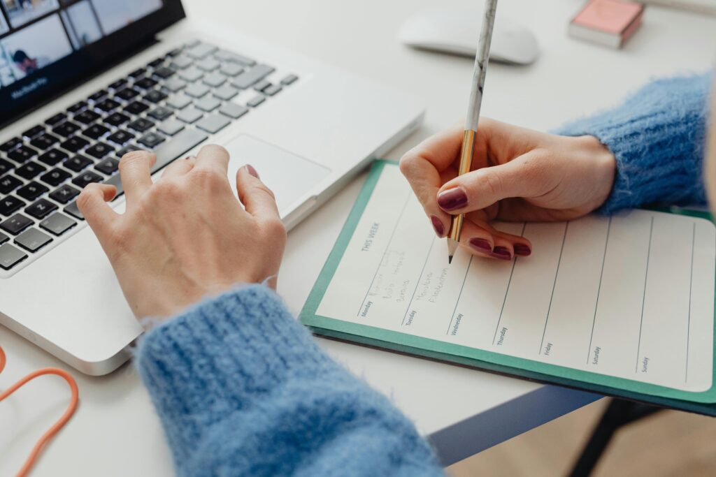 Woman scheduling talks on a planner to create an organized timeline for moving to France and applying for a visa.